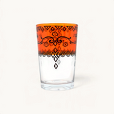 TUYYA Sonor 6oz Moroccan tea glass featuring a vibrant orange rim with intricate black hand-painted floral patterns.