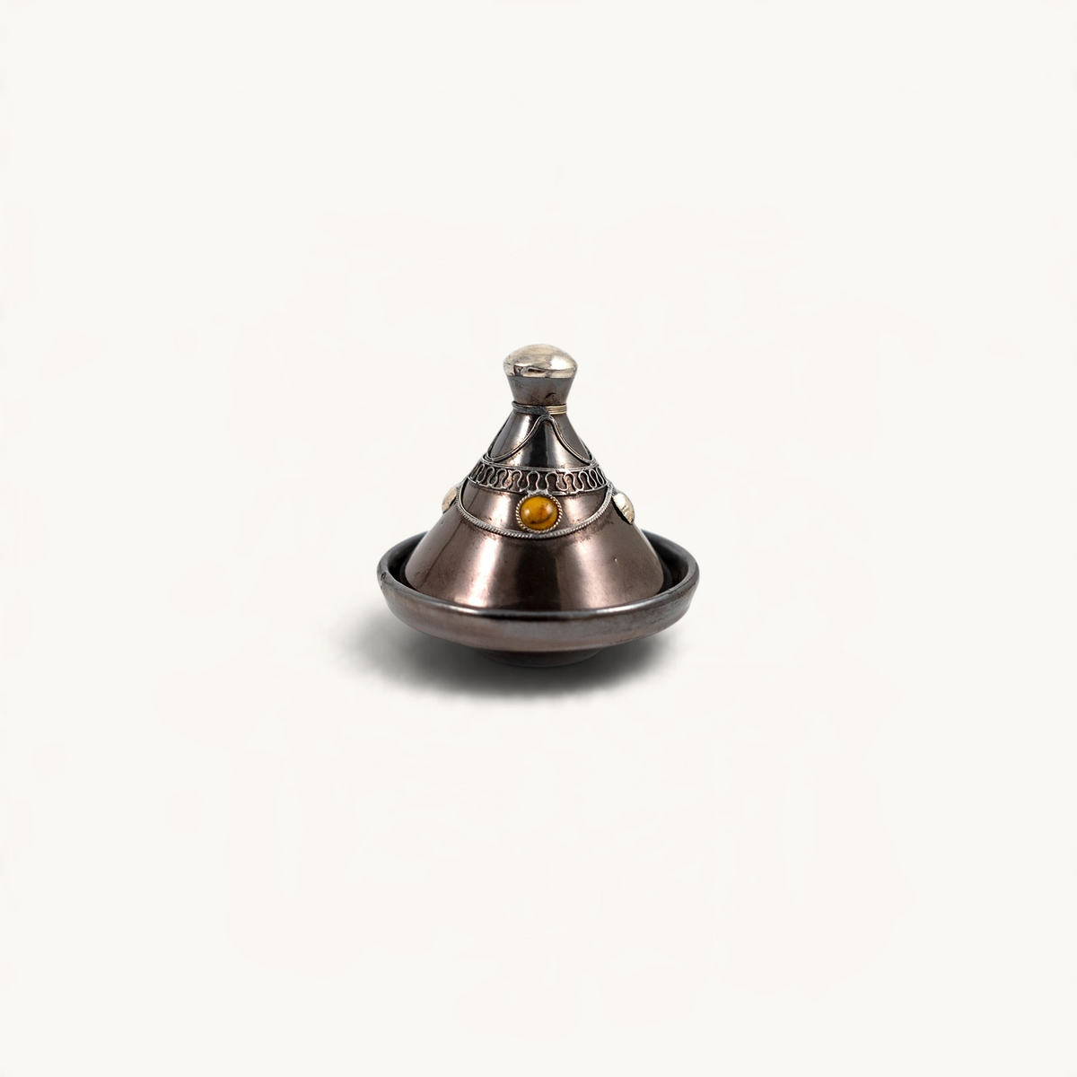 TUYYA handcrafted Moroccan mini tajine in dark ceramic with silver metal ornaments and amber-toned decorative inlay.
