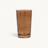 TUYYA Cadencia 4 oz tea glass in amber with intricate swirl patterns and traditional Moroccan design