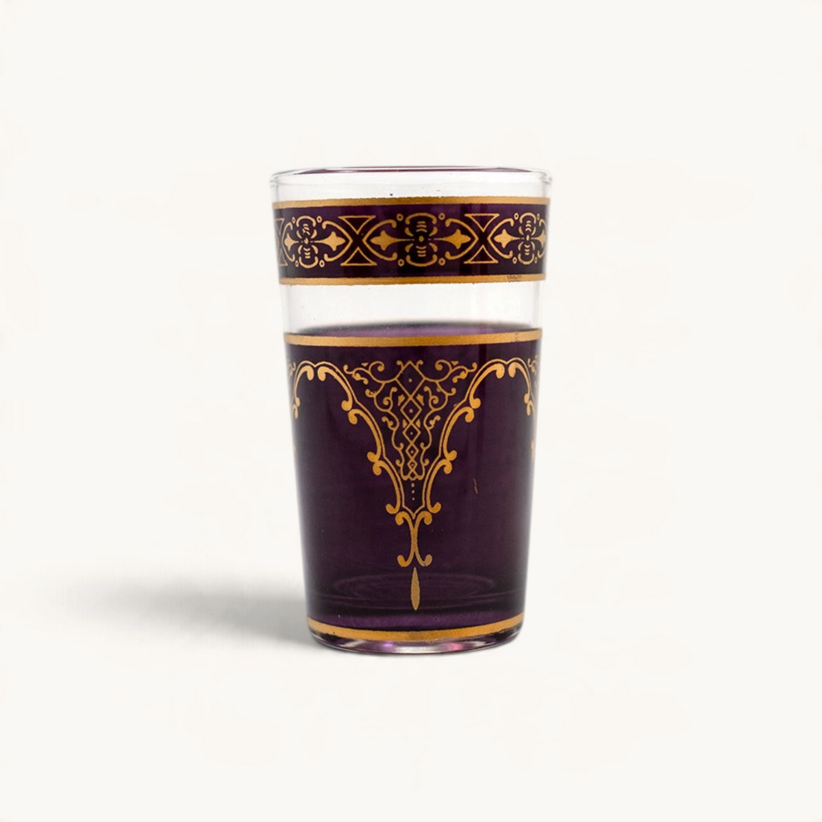 TUYYA Andalousia 4 oz tea cup in deep purple glass with intricate gold Berber pendant and decorative border designs.