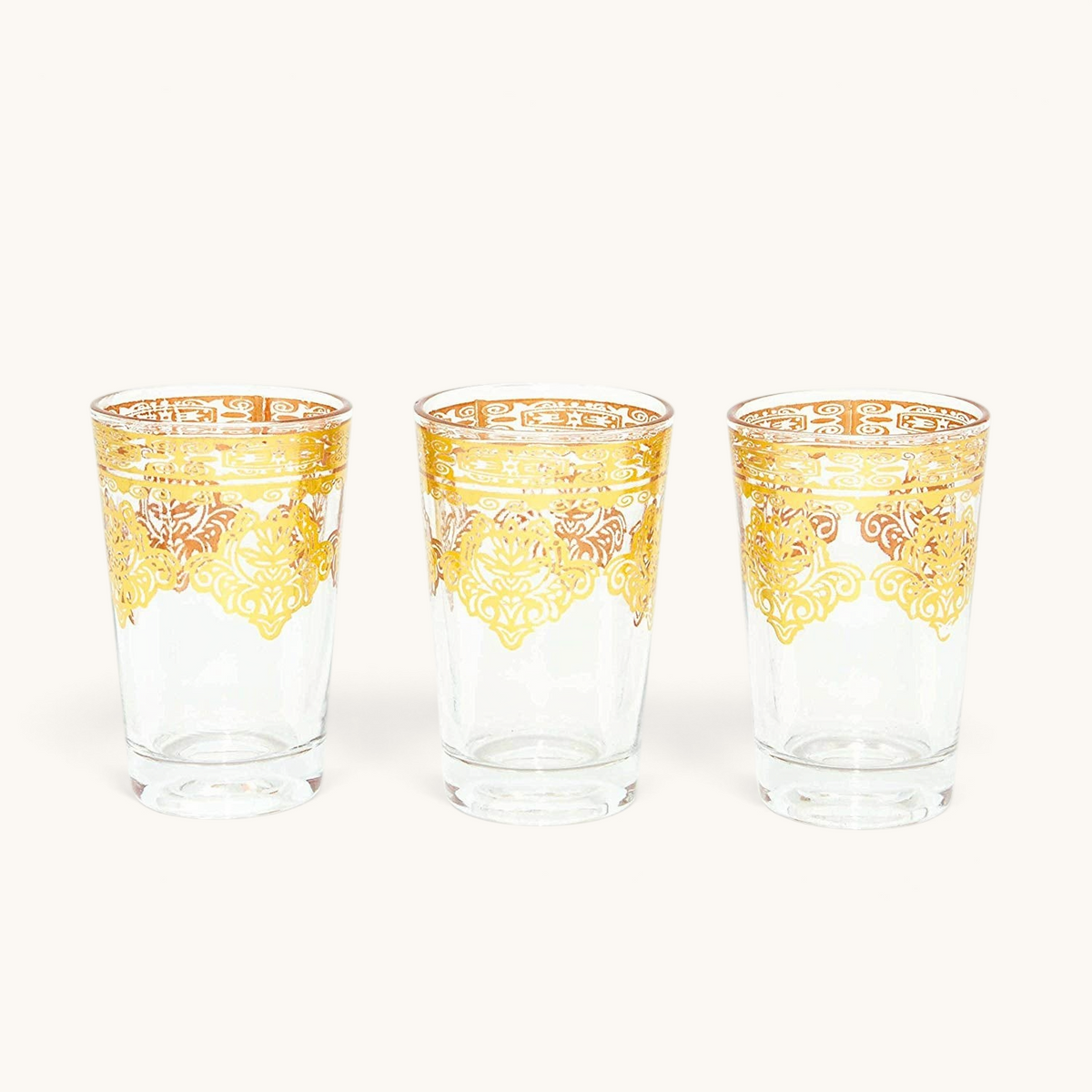Set of three tuyya golden Moroccan tea cups featuring intricate gold filigree patterns on clear glass