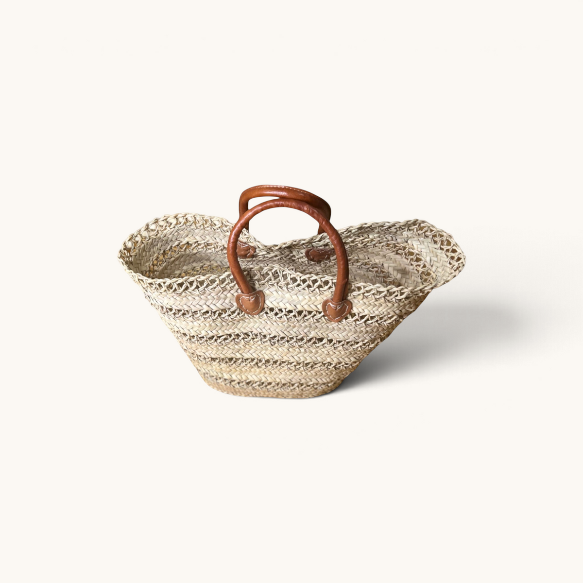 TUYYA handwoven Moroccan palm leaf basket featuring sturdy brown camel leather handles and decorative etched lines.