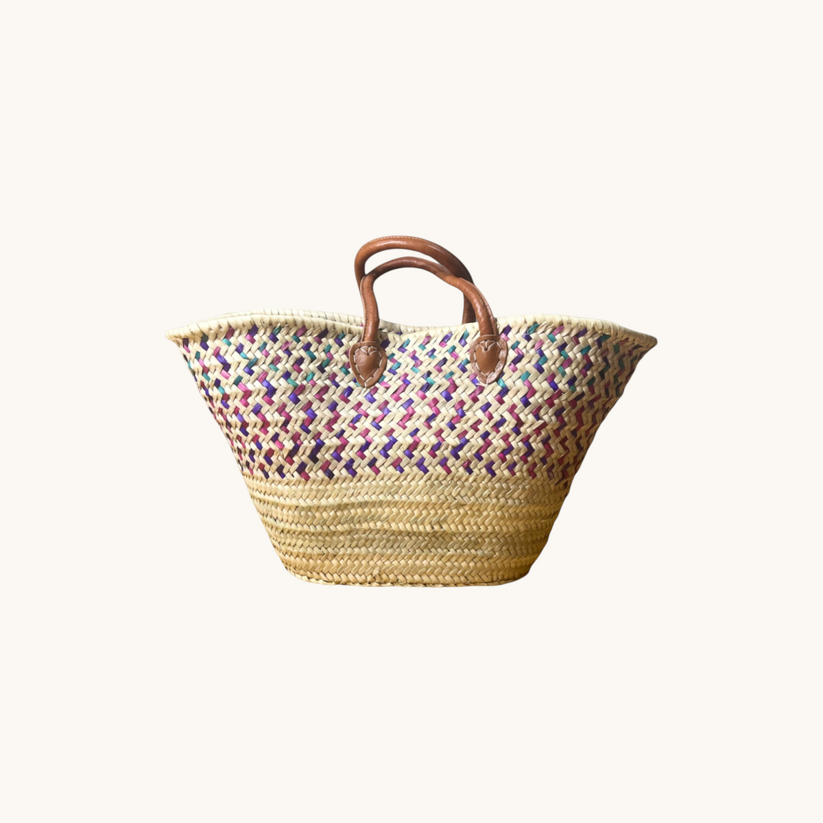 TUYYA Moroccan wicker basket with green, eggplant, and light mauve woven patterns and sturdy brown leather handles.