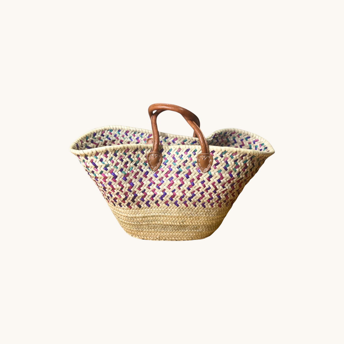 TUYYA handwoven Moroccan wicker basket with green, eggplant, and light mauve patterns and brown leather handles.