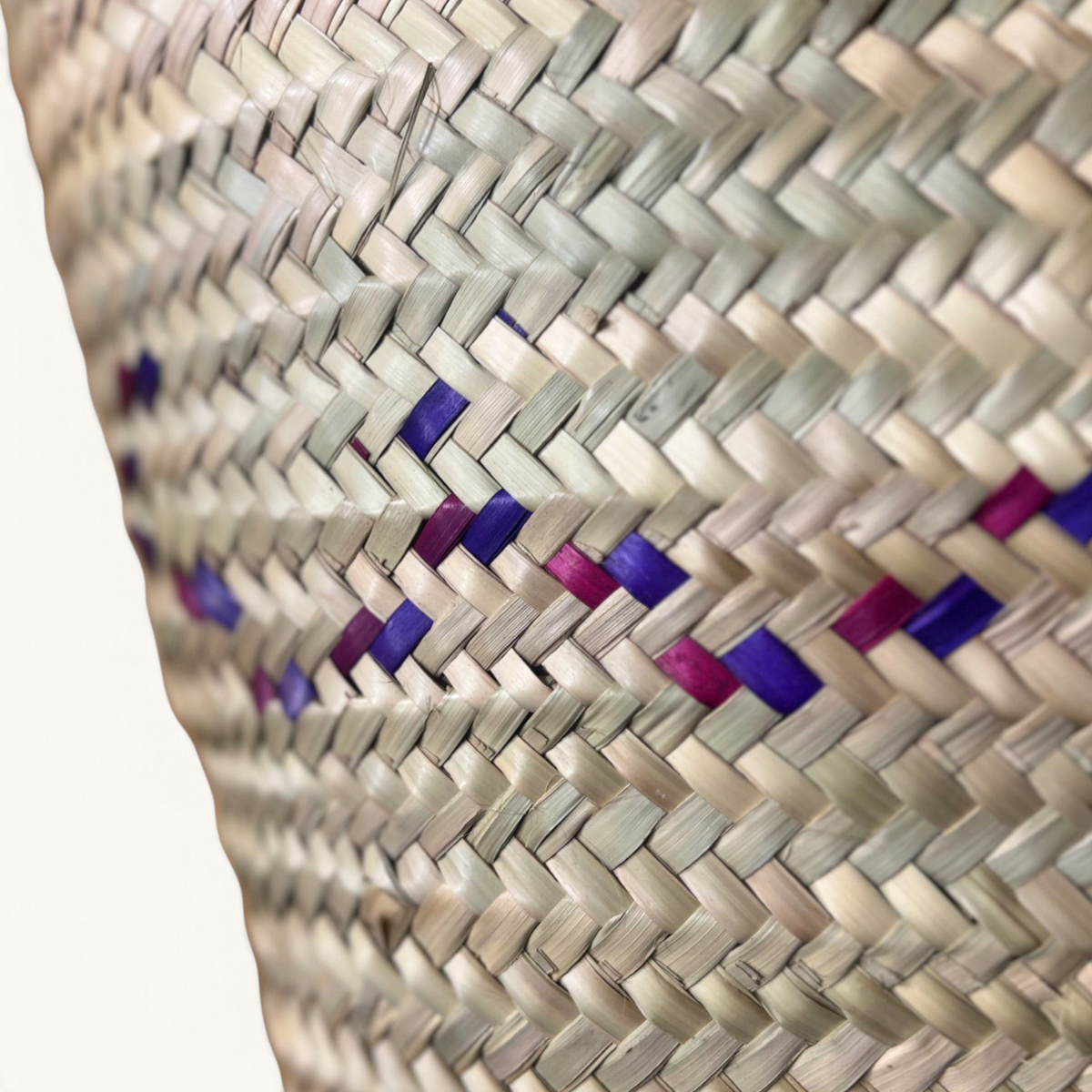 TUYYA Heydi Moroccan wicker basket featuring a close-up of handwoven natural straw with purple and pink wavy patterns.