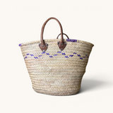 TUYYA Moroccan wicker basket featuring purple wave patterns and sturdy brown leather handles with metallic rivets.