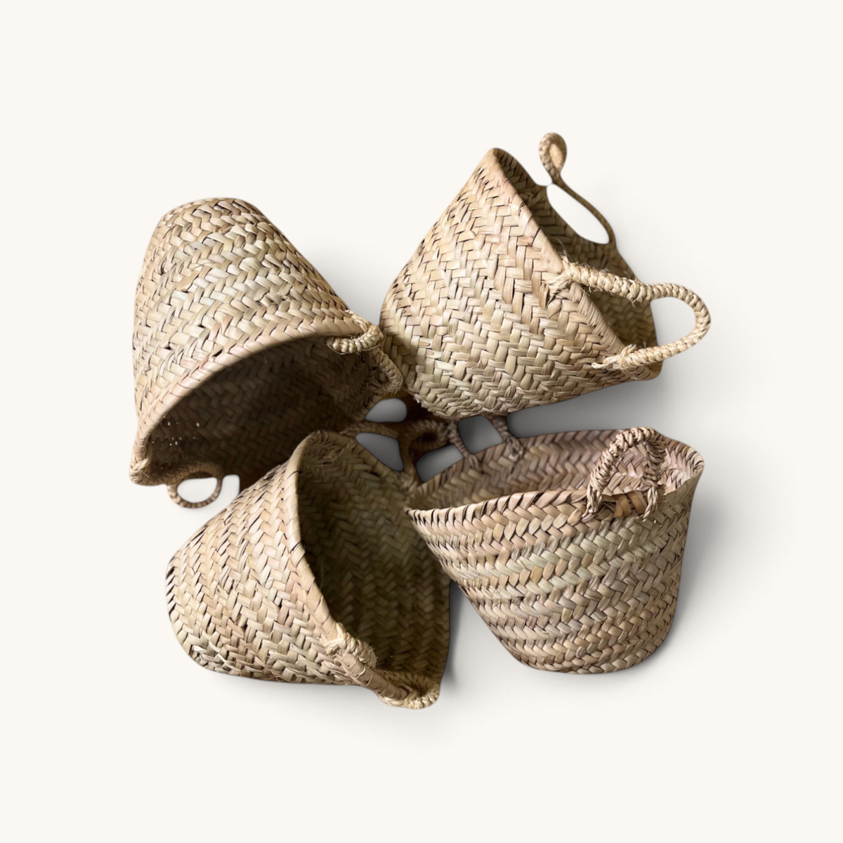 tuyya Soussou petite handcrafted Moroccan wicker baskets with two different handle designs arranged on white