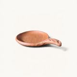 TUYYA handcrafted Moroccan unglazed clay cooking pan with a rustic textured handle on a plain background