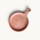 TUYYA handcrafted Moroccan unglazed clay cooking pan with a rustic textured handle, top-down view.