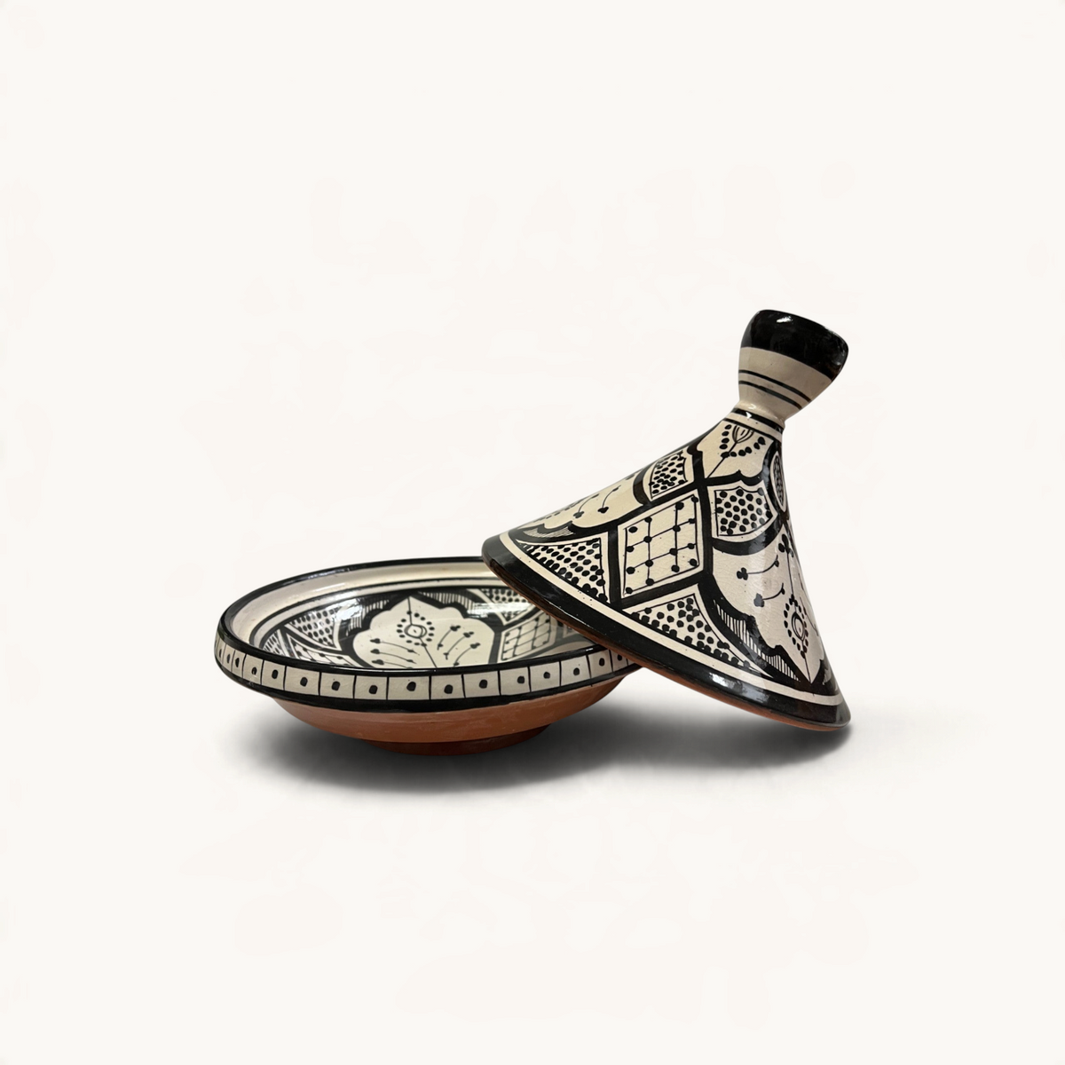 Tajine marocain TUYYA en céramique noir et blanc avec motifs floraux peints à la main, idéal pour le service.