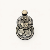 Tajine TUYYA en céramique noir et blanc avec motifs floraux marocains peints à la main, vue de dessus.