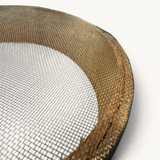 Close-up of a TUYYA handcrafted Moroccan wooden sieve with a fine metal mesh, showing natural wood grain and texture.