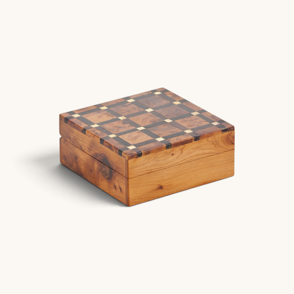 A beautifully handcrafted Thuya Woodbox with lemon wood inlays in an intricate lattice pattern on top, showcasing the artistry of Moroccan craftsmen by TUYYA.
