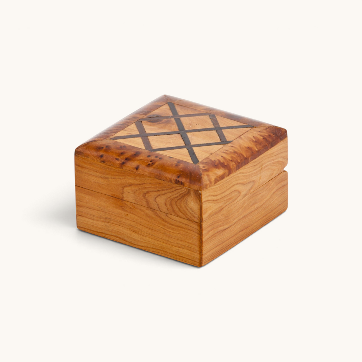 An elegant Thuya Woodbox with mahogany inlays, showcasing a unique shape and expressive thuya burl, handcrafted by Moroccan artisans, presented by TUYYA.