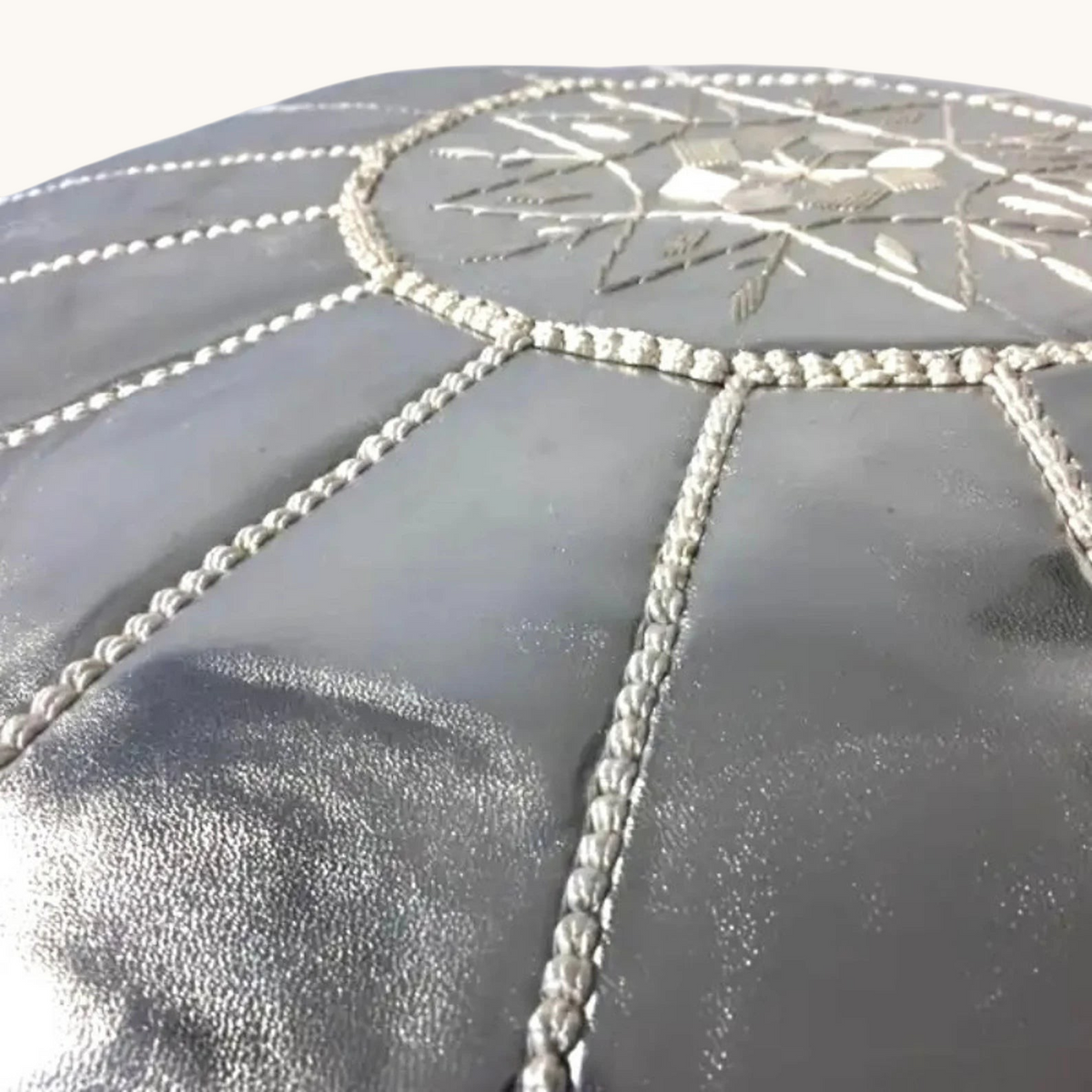 tuyya silver Moroccan vegan leather pouf with intricate hand-embroidered detailing on the top surface