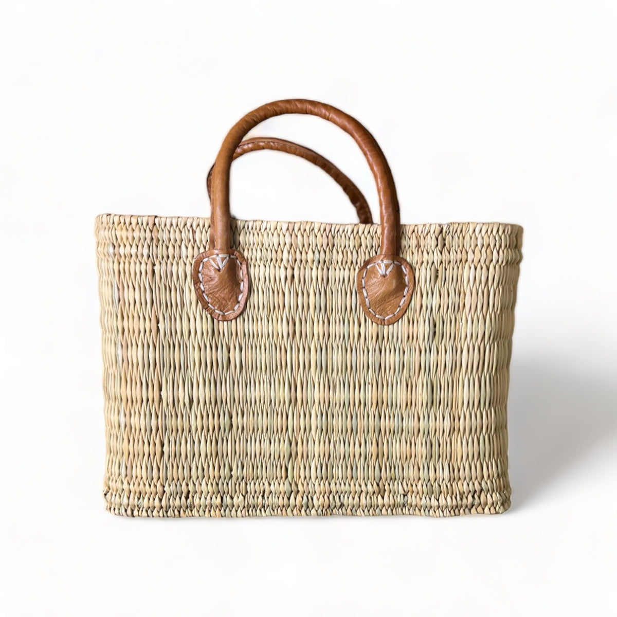 tuyya Yasmine structured Moroccan wicker basket with camel-colored leather handles and hand-stitched rivet details.