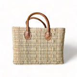 tuyya Yasmine structured Moroccan wicker basket with camel-colored leather handles and hand-stitched rivet details.