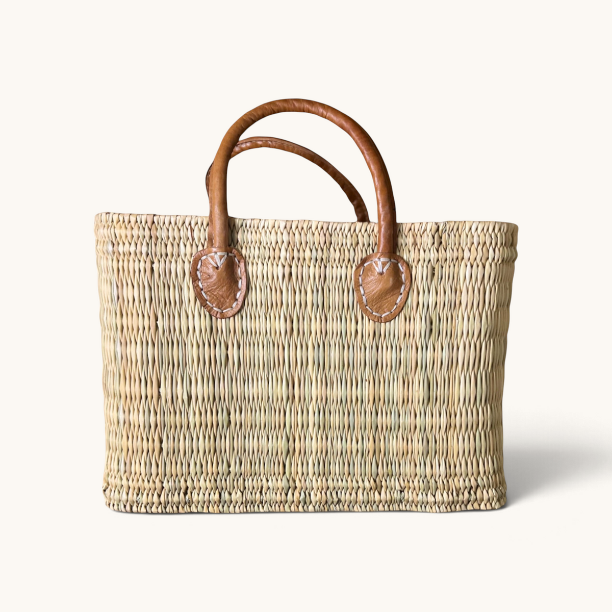 tuyya Yasmine structured Moroccan wicker basket with camel-colored leather handles and hand-stitched rivet details.