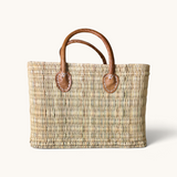 tuyya Yasmine structured Moroccan wicker basket with camel-colored leather handles and hand-stitched rivet details.