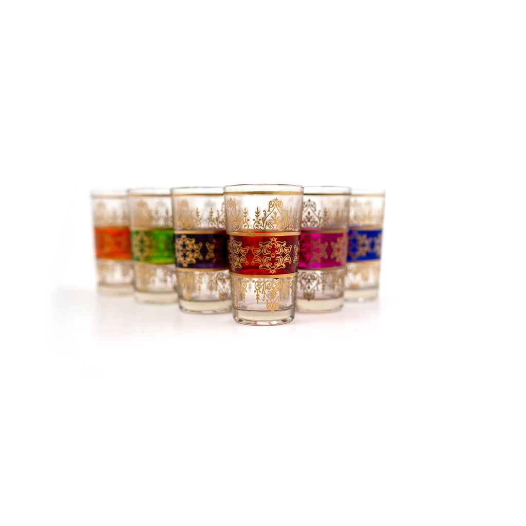 Set of 6 'Tunis' Moroccan tea glasses from TUYYA, each with a colorful band and golden arabesque floral designs. Colors include orange, green, mauve, red, fuchsia, and blue.